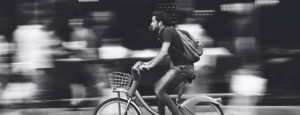 Can You Claim Damages If Not Wearing a Helmet? - banner image - man riding a bicycle at high speed without a helmet.