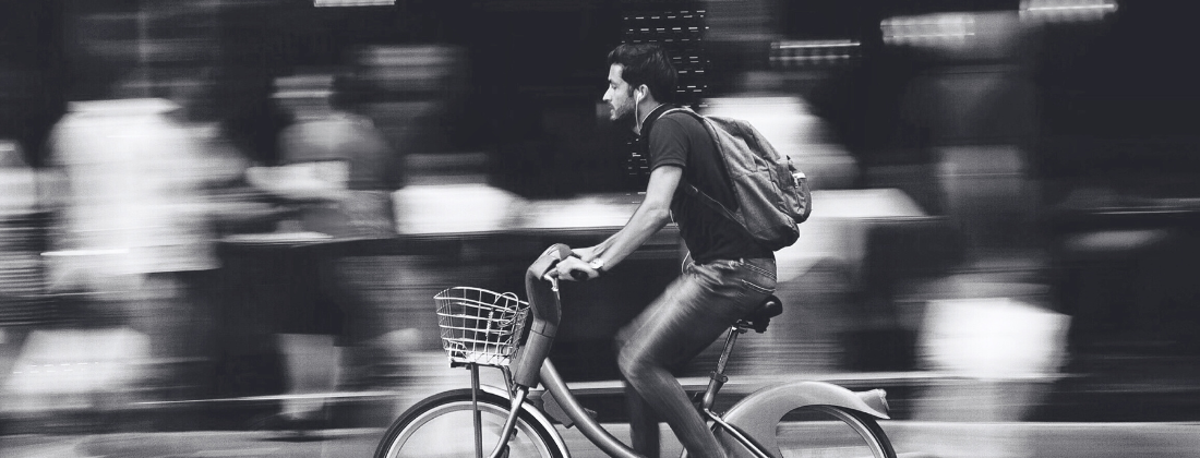Can You Claim Damages If Not Wearing a Helmet? - banner image - man riding a bicycle at high speed without a helmet.