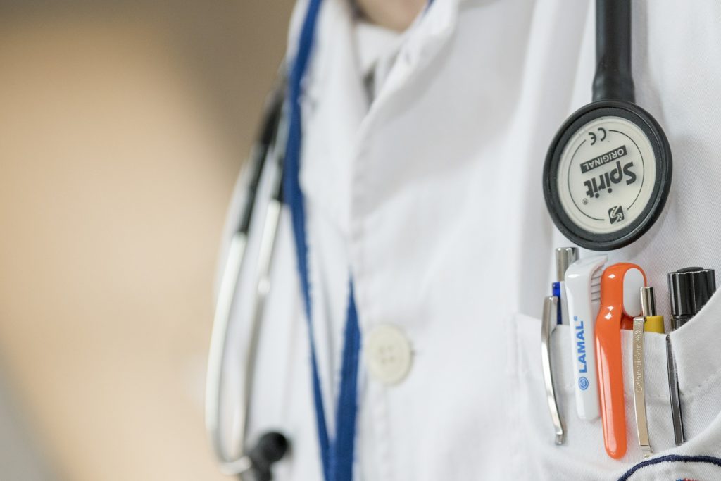 doctor in white rob with stethoscope and pens in front pocket.