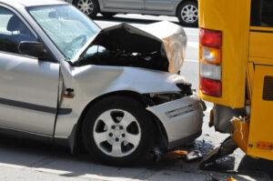 Car rear ends a yellow bus
