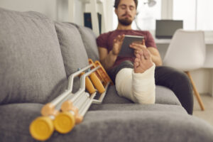 Injured man in a leg cast resting.