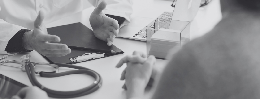 Patient consulting with a doctor at a desk, with a stethoscope and clipboard visible, highlighting medical treatment discussions after an accident.