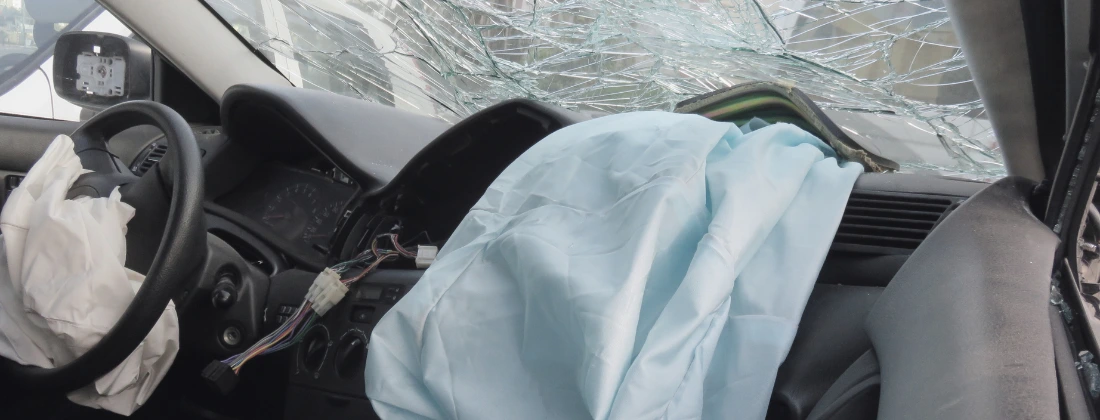 crashed car with damage and airbags deployed