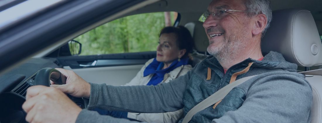 Happy older couple driving in a car