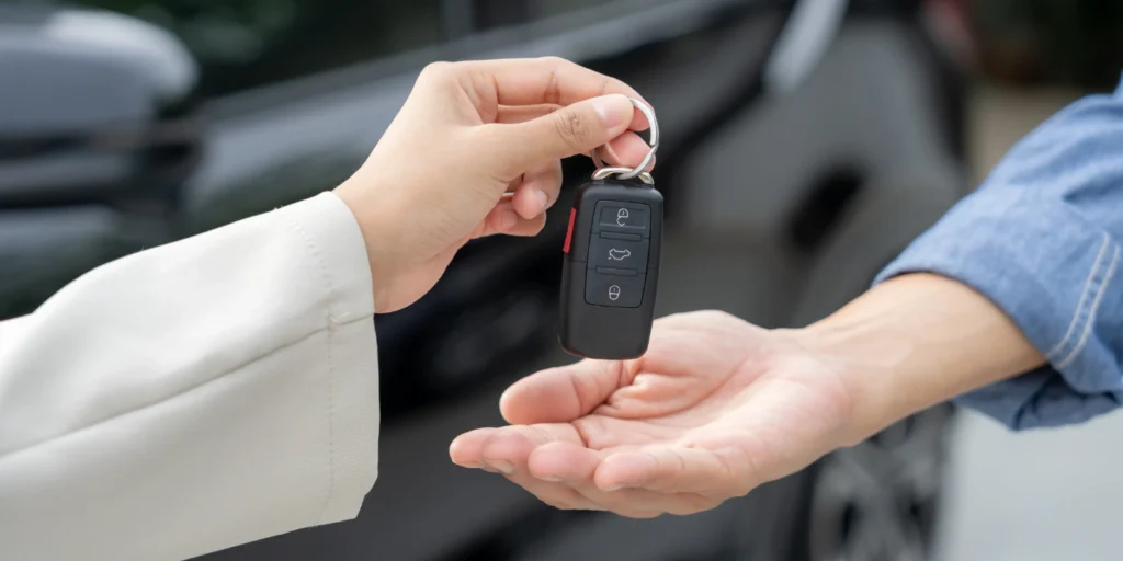 car owner handing car keys to another person