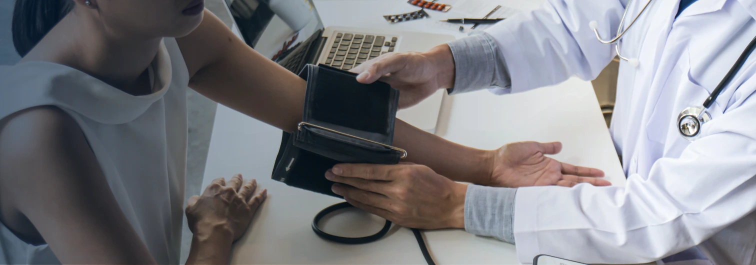woman getting her blood pressure taken during a medical evaluation