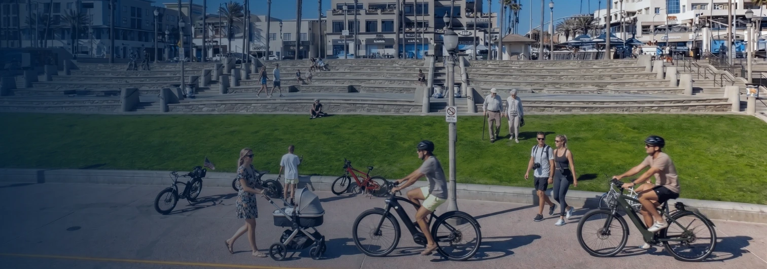 Electric bike rider on the Huntington Beach Strand with pedestrians walking nearby