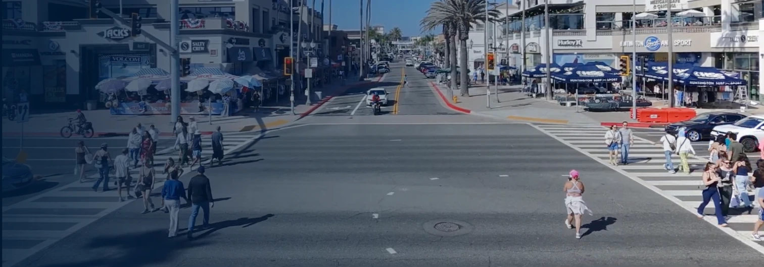 Pedestrian mid-crossing at a marked crosswalk on Pacific Coast Highway near the Huntington Beach pier