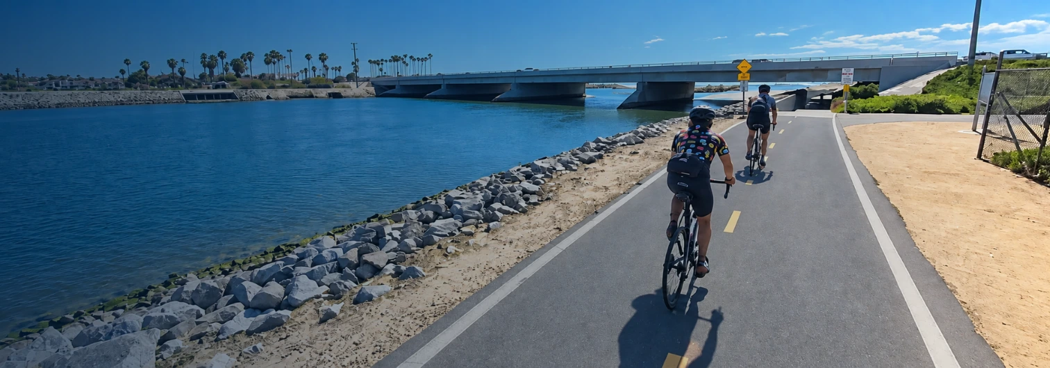 Cyclists riding on the Santa Ana River Trail near Huntington Beach, California